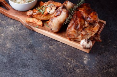 Kemiğin üzerinde büyük bir parça kızarmış et. Josper 'da kızartılmış sarımsak. Büyük parçalar halinde ızgara patates..