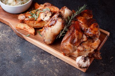 Kemiğin üzerinde büyük bir parça kızarmış et. Josper 'da kızartılmış sarımsak. Büyük parçalar halinde ızgara patates..