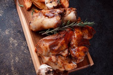 Kemiğin üzerinde büyük bir parça kızarmış et. Josper 'da kızartılmış sarımsak. Büyük parçalar halinde ızgara patates..