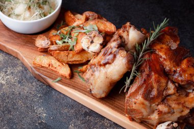 Kemiğin üzerinde büyük bir parça kızarmış et. Josper 'da kızartılmış sarımsak. Büyük parçalar halinde ızgara patates..