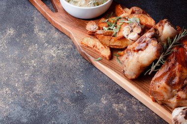 Kemiğin üzerinde büyük bir parça kızarmış et. Josper 'da kızartılmış sarımsak. Büyük parçalar halinde ızgara patates..