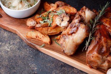 Kemiğin üzerinde büyük bir parça kızarmış et. Josper 'da kızartılmış sarımsak. Büyük parçalar halinde ızgara patates..