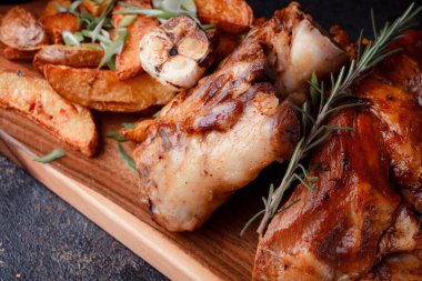 Kemiğin üzerinde büyük bir parça kızarmış et. Josper 'da kızartılmış sarımsak. Büyük parçalar halinde ızgara patates..