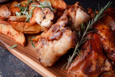 Kemiğin üzerinde büyük bir parça kızarmış et. Josper 'da kızartılmış sarımsak. Büyük parçalar halinde ızgara patates..