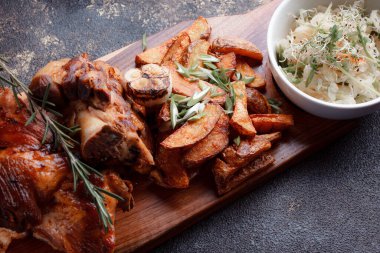 Kemiğin üzerinde büyük bir parça kızarmış et. Josper 'da kızartılmış sarımsak. Büyük parçalar halinde ızgara patates..