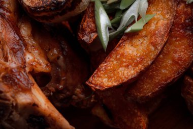 Kemiğin üzerinde büyük bir parça kızarmış et. Josper 'da kızartılmış sarımsak. Büyük parçalar halinde ızgara patates..