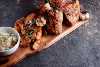 Kemiğin üzerinde büyük bir parça kızarmış et. Josper 'da kızartılmış sarımsak. Büyük parçalar halinde ızgara patates..