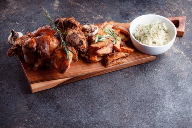 Kemiğin üzerinde büyük bir parça kızarmış et. Josper 'da kızartılmış sarımsak. Büyük parçalar halinde ızgara patates..