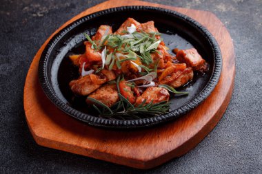 Kızarmış et ve karamelli soslu sıcak tava. Pişmiş ve taze sebzeler garnitür ve garnitür olarak..