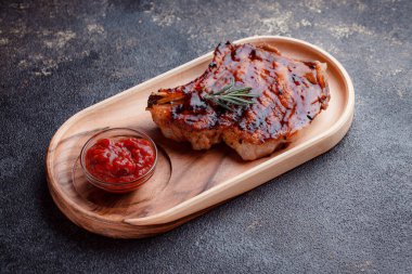 Karamelli soslu ızgara domuz eti. Çevre dostu ahşap kaplarda et servisi. Taze biberiye ve domates sosu..