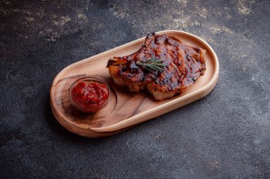 Karamelli soslu ızgara domuz eti. Çevre dostu ahşap kaplarda et servisi. Taze biberiye ve domates sosu..