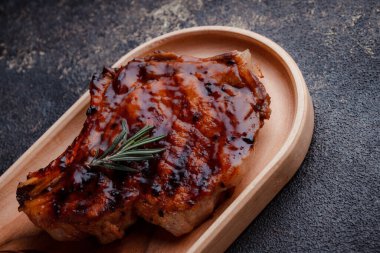 Karamelli soslu ızgara domuz eti. Çevre dostu ahşap kaplarda et servisi. Taze biberiye ve domates sosu..