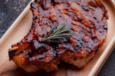 Karamelli soslu ızgara domuz eti. Çevre dostu ahşap kaplarda et servisi. Taze biberiye ve domates sosu..