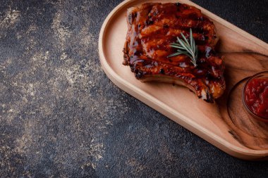 Karamelli soslu ızgara domuz eti. Çevre dostu ahşap kaplarda et servisi. Taze biberiye ve domates sosu..