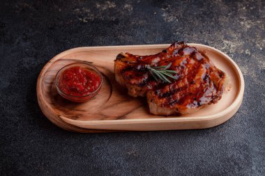 Karamelli soslu ızgara domuz eti. Çevre dostu ahşap kaplarda et servisi. Taze biberiye ve domates sosu..