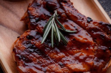 Karamelli soslu ızgara domuz eti. Çevre dostu ahşap kaplarda et servisi. Taze biberiye ve domates sosu..