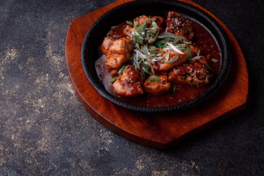 Kızarmış et ve karamelli soslu sıcak tava. Pişirilmiş ve garnitür olarak taze sebzeler. Keten tohumu ve susam tohumu eklenmiş bir yemek..