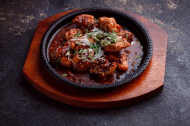 Kızarmış et ve karamelli soslu sıcak tava. Pişirilmiş ve garnitür olarak taze sebzeler. Keten tohumu ve susam tohumu eklenmiş bir yemek..