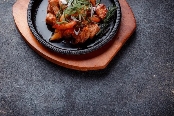 Kızarmış et ve karamelli soslu sıcak tava. Pişmiş ve taze sebzeler garnitür ve garnitür olarak..