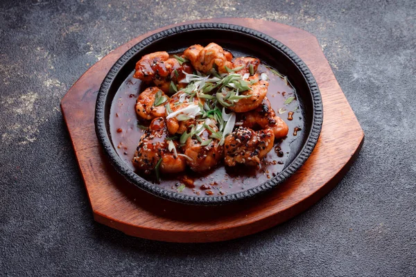 Kızarmış et ve karamelli soslu sıcak tava. Pişirilmiş ve garnitür olarak taze sebzeler. Keten tohumu ve susam tohumu eklenmiş bir yemek..