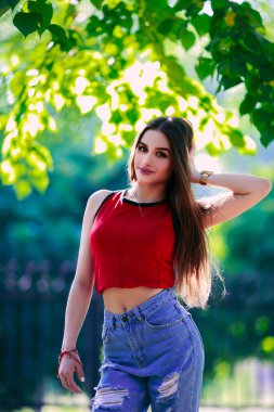 Uzun saçlı, güzel ve ciddi bir yüz ifadesi olan kız. Yaz yürüyüşü kıyafetleri. Kişisel bakım kavramı. Yüzünde mutlu duygular.