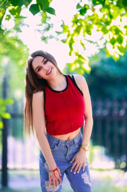 Uzun saçlı, güzel ve ciddi bir yüz ifadesi olan kız. Yaz yürüyüşü kıyafetleri. Kişisel bakım kavramı. Yüzünde mutlu duygular.