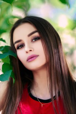 Uzun saçlı, güzel ve ciddi bir yüz ifadesi olan kız. Yaz yürüyüşü kıyafetleri. Kişisel bakım kavramı. Yüzünde mutlu duygular.