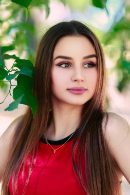 Uzun saçlı, güzel ve ciddi bir yüz ifadesi olan kız. Yaz yürüyüşü kıyafetleri. Kişisel bakım kavramı. Yüzünde mutlu duygular.
