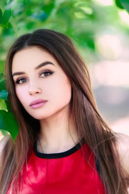 Uzun saçlı, güzel ve ciddi bir yüz ifadesi olan kız. Yaz yürüyüşü kıyafetleri. Kişisel bakım kavramı. Yüzünde mutlu duygular.