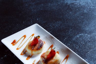 Kırmızı somon havyarlı krep. Koyu mavi arka planda güzel bir yemek servisi. Restoran tatlı menüsü.