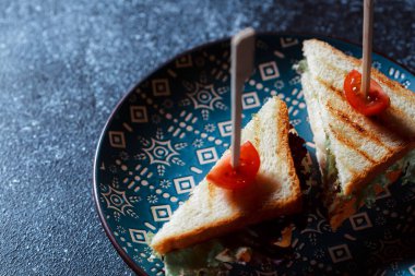Beyaz ekmekten yapılmış etli sandviç. Koyu mavi tabakta beyaz ekmek sandviçleri. Restoranda bulaşık servisi. Fast food konsepti. Bir yazı için boş alan.