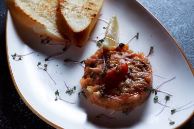 Sebze salatası ve kızarmış cips. Restoranda servis edilen bir yemek. Koyu mavi arka planda beyaz plaka.