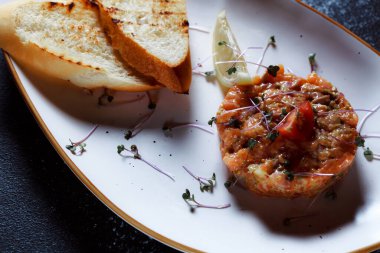 Sebze salatası ve kızarmış cips. Restoranda servis edilen bir yemek. Koyu mavi arka planda beyaz plaka.