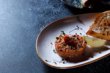 Sebze salatası ve kızarmış cips. Restoranda servis edilen bir yemek. Koyu mavi arka planda beyaz plaka.