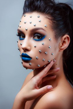 Güzellik tarzında makyaj. Parlak dudaklar ve gözler. Güzel bir genç kızın portresi. Günlük detaylı cilt rötuşları. Etkileyici kaşlar. Kocaman kirpikleri var. Neon gölgeleri.