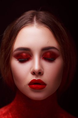 Güzellik tarzında makyaj. Parlak dudaklar ve gözler. Güzel bir genç kızın portresi. Günlük detaylı cilt rötuşları. Etkileyici kaşlar. Kocaman kirpikleri var. Neon gölgeleri.