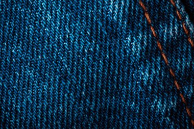 Mavi kot kumaşı. Denim makine dikişi. Harfler ya da tasarım için arkaplan olarak kullanılabilir. Fabrika terziliği. Pamuk kumaş. Kot pantolon moda..