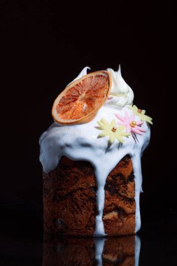 Bayram masasında Paskalya pastası. Koyu bir arka planda coşkulu bahar renkleri olan şenlikli pişmiş yiyecekler..