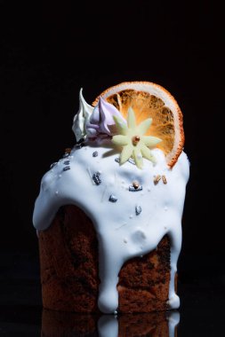 Bayram masasında Paskalya pastası. Koyu bir arka planda coşkulu bahar renkleri olan şenlikli pişmiş yiyecekler..