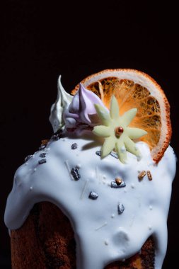 Bayram masasında Paskalya pastası. Koyu bir arka planda coşkulu bahar renkleri olan şenlikli pişmiş yiyecekler..