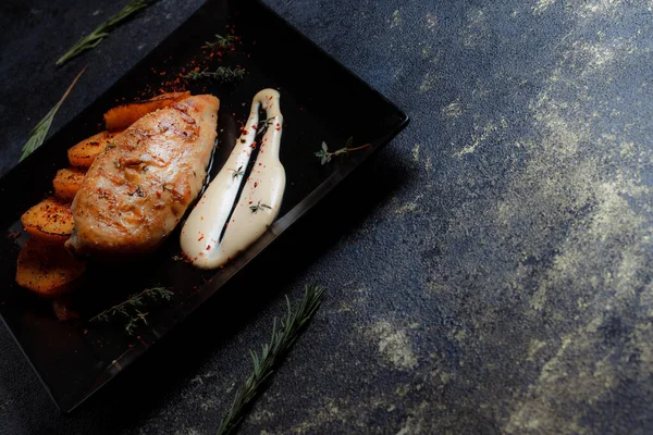 Grilovaný Kuřecí Steak Kořením Pečenými Brambory Černém Talíři Tmavém Texturovaném — Stock fotografie