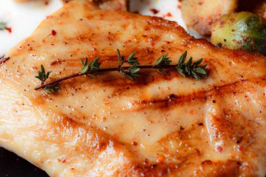 Sebzeli biftek ve siyah tabakta ızgara mantar. Baharatlar - biber, maydanoz, fesleğen, kekik, beyaz sarımsak sosu. Kızarmış etin detaylı dokusu.