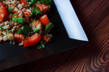 Yeşil yapraklı ve sebzeli salata. Lean vejetaryen yemeği. Hafif salata, domatesli marul, bulgur, maydanoz, baharatlı susam tohumu..