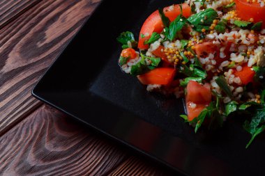 Yeşil yapraklı ve sebzeli salata. Lean vejetaryen yemeği. Hafif salata, domatesli marul, bulgur, maydanoz, baharatlı susam tohumu..