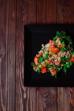 Yeşil yapraklı ve sebzeli salata. Lean vejetaryen yemeği. Hafif salata, domatesli marul, bulgur, maydanoz, baharatlı susam tohumu..