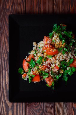 Yeşil yapraklı ve sebzeli salata. Lean vejetaryen yemeği. Hafif salata, domatesli marul, bulgur, maydanoz, baharatlı susam tohumu..