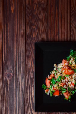 Yeşil yapraklı ve sebzeli salata. Lean vejetaryen yemeği. Hafif salata, domatesli marul, bulgur, maydanoz, baharatlı susam tohumu..