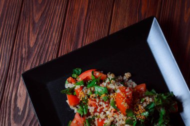 Yeşil yapraklı ve sebzeli salata. Lean vejetaryen yemeği. Hafif salata, domatesli marul, bulgur, maydanoz, baharatlı susam tohumu..