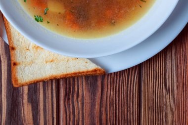 Tahta tepside ekmekle sebze çorbası. Koyu renk tahta arka planda beyaz kase. Üst Manzara. Boşluğu kopyala.