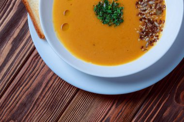 Tahta tepside ekmekle sebze çorbası. Koyu renk tahta arka planda beyaz kase. Üst Manzara. Boşluğu kopyala.